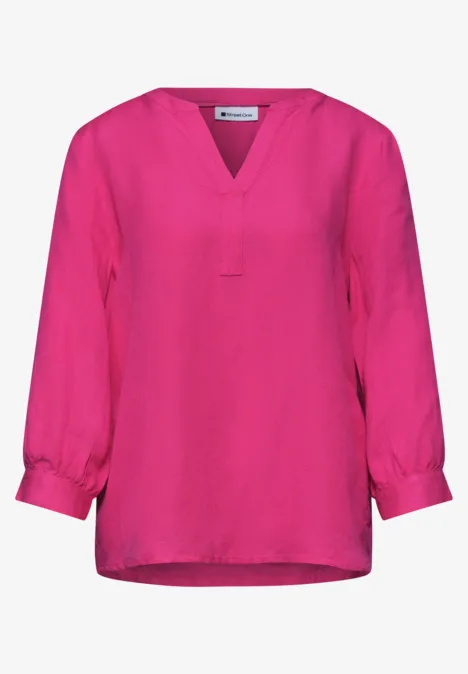 Helles, locker geschnittenes pinkfarbenes Oberteil mit V-Ausschnitt und 3/4-Ärmeln.