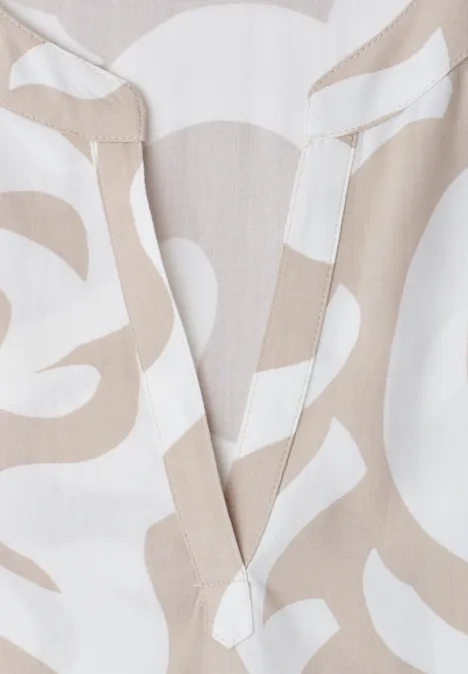 Tissu beige et blanc à motif abstrait aux formes organiques et arrondies.