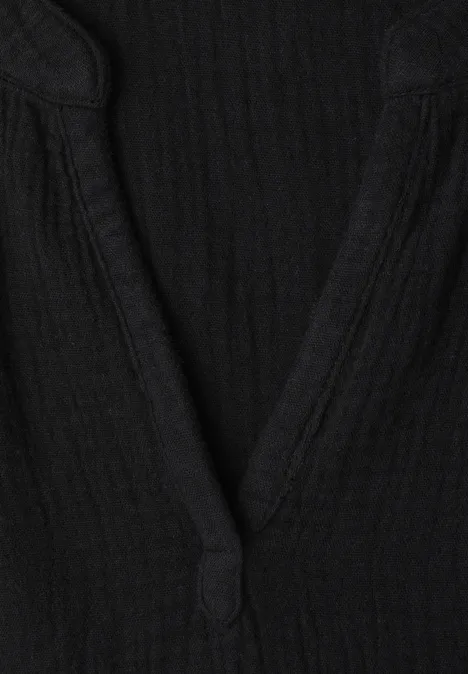 Zwart topje met V-hals van geribbelde stof.