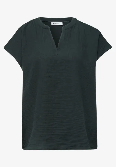 Donkergroene damesblouse met korte mouwen, V-hals en subtiele structuur.