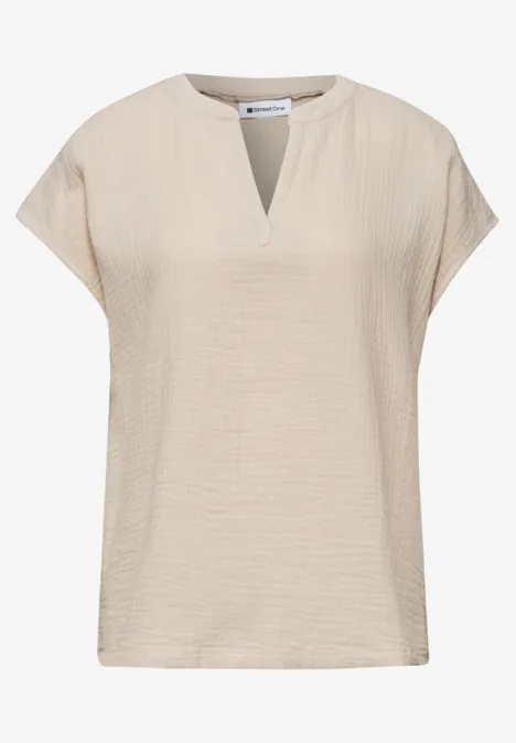 Beige dames top met korte mouwen, losse pasvorm en kleine V-hals.