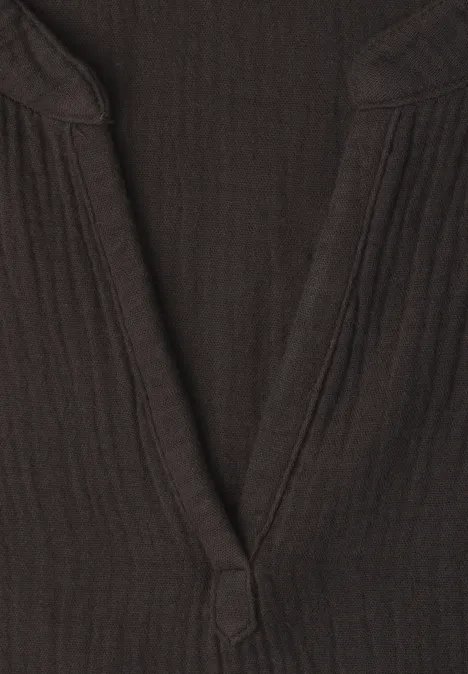 Gros plan d'un col en V côtelé de couleur brun foncé sur un haut.