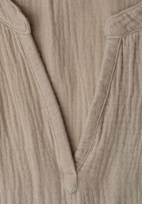 Beige linnen top met V-hals en gestructureerd oppervlak.