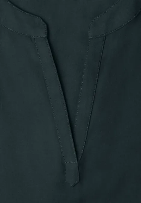 Dunkelblaues Oberteil aus leicht strukturiertem Stoff mit V-Ausschnitt und Nahtdetail in der Mitte.