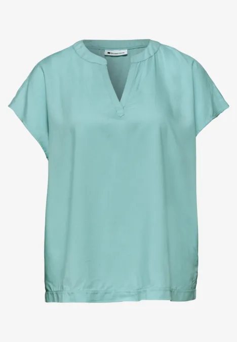 Blouse vert menthe à manches courtes, encolure en V et coupe ample.