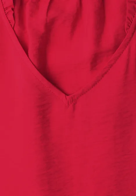 Een rood V-hals shirt van gladde stof.