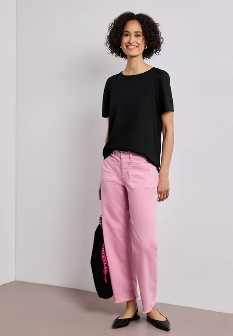 Blouse met ronde hals en korte pofmouwen Black Persoon draagt zwart T-shirt, roze broek, zwarte ballerina’s en zwarte tas.