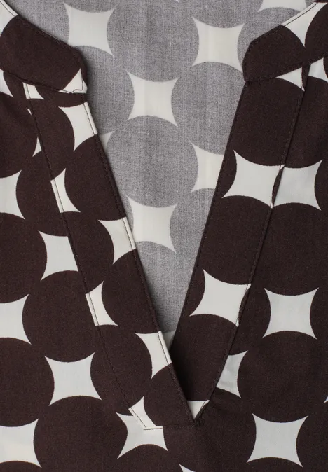 Dunkelbraunes Wickeloberteil mit auffälligem, weißem Kreisstern-Muster.