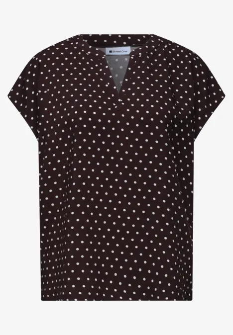 Schwarzes Damen-Shirt mit V-Ausschnitt und weißen Punkten.