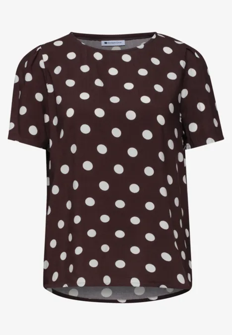 T-shirt marron à pois blancs, manches courtes.