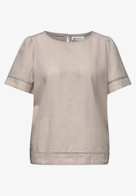 Beige dames top met korte mouwen, ronde hals en subtiele kanten boord.