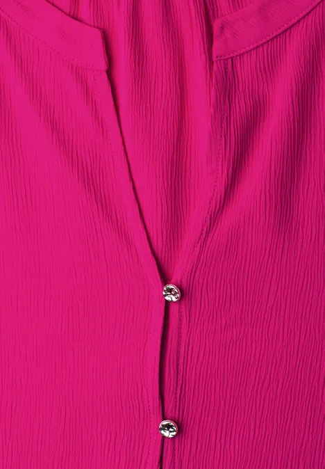 Fuchsia blouse met geribbelde textuur en twee fonkelende knopen middenvoor.