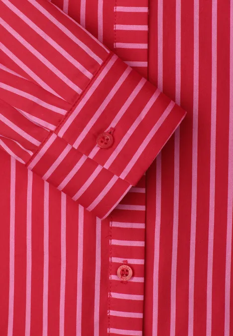 Rood overhemd met roze strepen en rode knopen, close-up van de mouwmanchet en knopenrij.