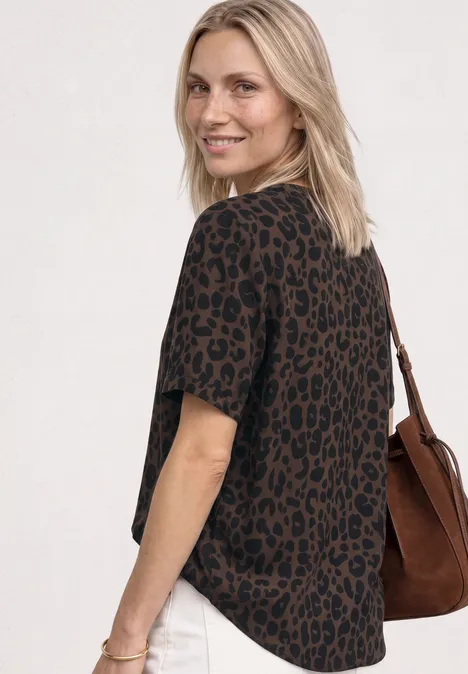 Frau im braun-schwarzen Leoparden-T-Shirt mit Schultertasche
