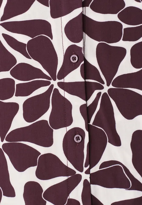 Top met wit diep-paars bloemenpatroon en opvallende knoopsluiting.