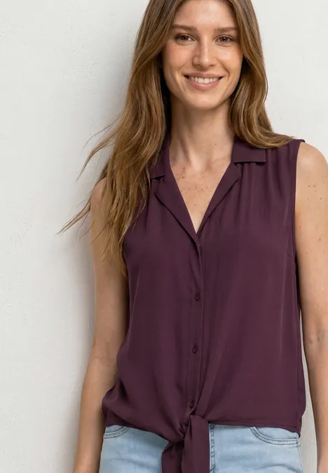 Blusentop mit Bowling-Kragen und Knoten rustic rouge Frau in ärmelloser, kastanienbrauner Bluse mit V-Ausschnitt und Knoten am Saum.