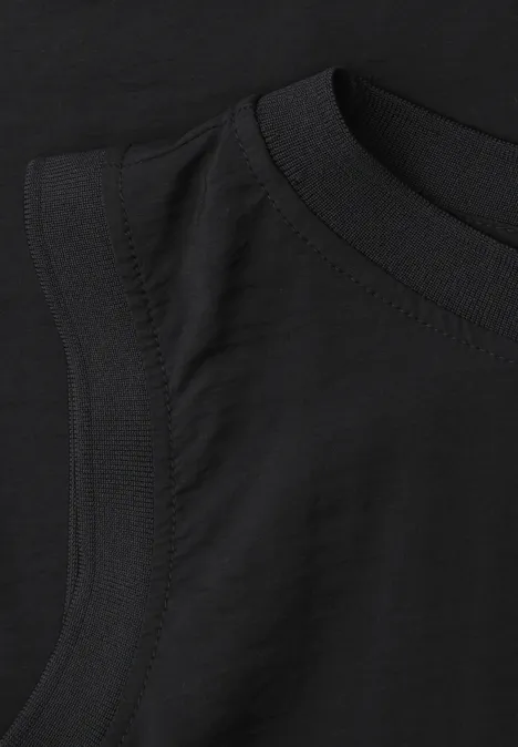 Schwarzes ärmelloses T-Shirt, Detailansicht von Rundhalsausschnitt und Ärmelausschnitt.
