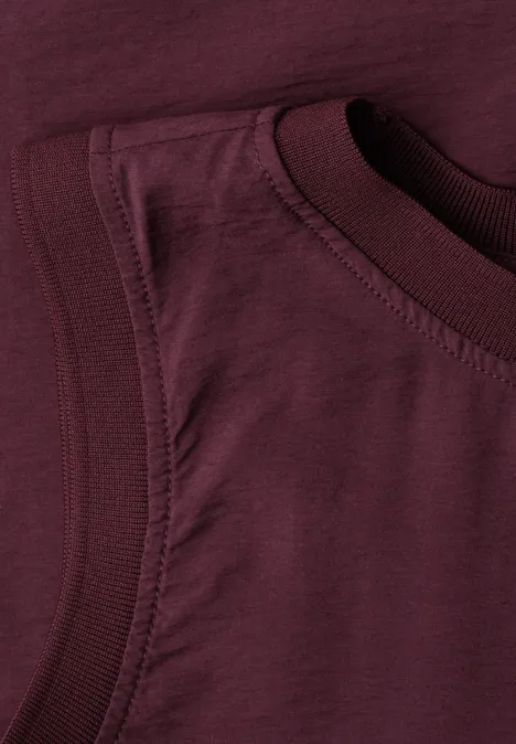 Blusentop mit Rundhals und Tape-Detail rustic rouge Bild zeigt eine Nahaufnahme eines weinroten ärmellosen Baumwollshirts.