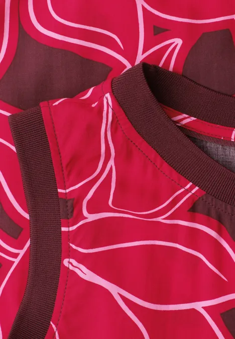 Nahaufnahme eines roten Ärmellosen Oberteils mit pink-weißen abstrakten Linien und dunkelroten Bündchen.