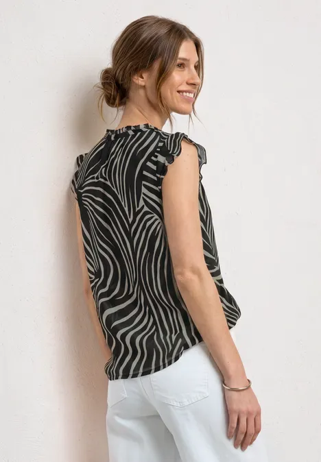 Frau von hinten in gestreiftem Top und weißer Hose, Haare zu einem Dutt gebunden.
