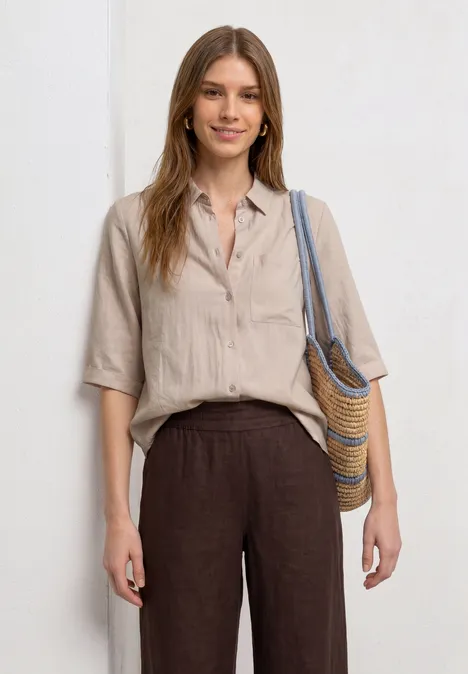 3/4-Arm Hemdbluse mit Brusttasche clay sand Frau in lockerer Leinenbluse, dunkler Leinenhose und Strohtasche über der Schulter.