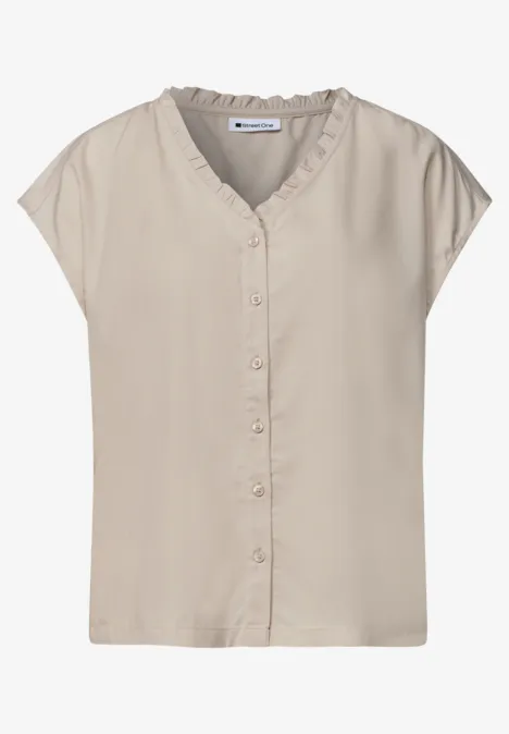 Beige mouwloze blouse met V-hals en knoopsluiting, losvallend model.