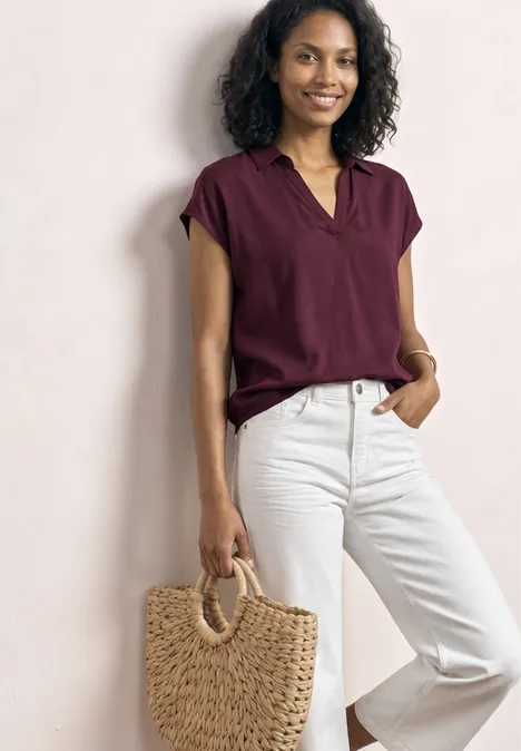 Blusenshirt mit Hemdkragen und Elastiksaum rustic rouge Eine Frau trägt ein burgunderfarbenes Oberteil, weiße Jeans und hält eine Strohtasche mit runden Griffen.