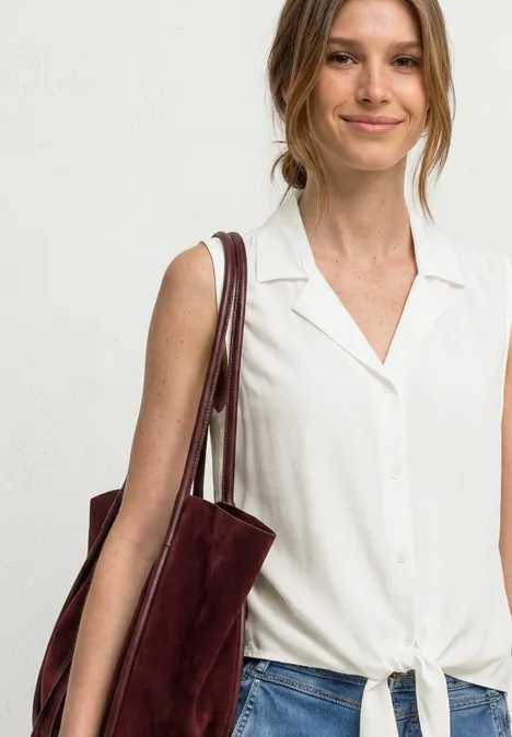 Blusentop mit Bowling-Kragen und Knoten off white Frau in weißer, geknoteter Bluse trägt burgunderfarbenen Wildleder-Shopper an der Schulter.