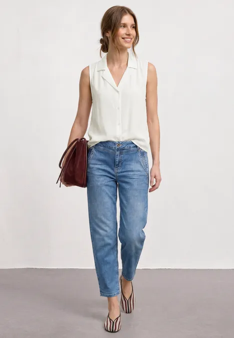 Blusentop mit Bowling-Kragen und Knoten off white Frau in weißer Bluse, blauen Jeans, Sandalen und mit roter Tasche.