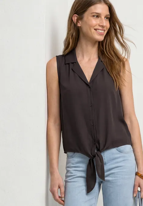 Blusentop mit Bowling-Kragen und Knoten espresso brown Eine junge Frau trägt eine ärmellose, knöpfbare Bluse mit Knoten vorne und eine helle Jeans.