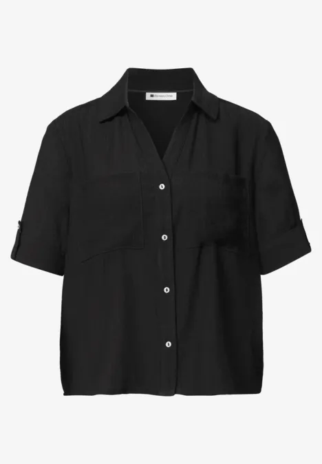 Zwart, kort mouw blouse met kentkraag, knoopsluiting en borstzakken.