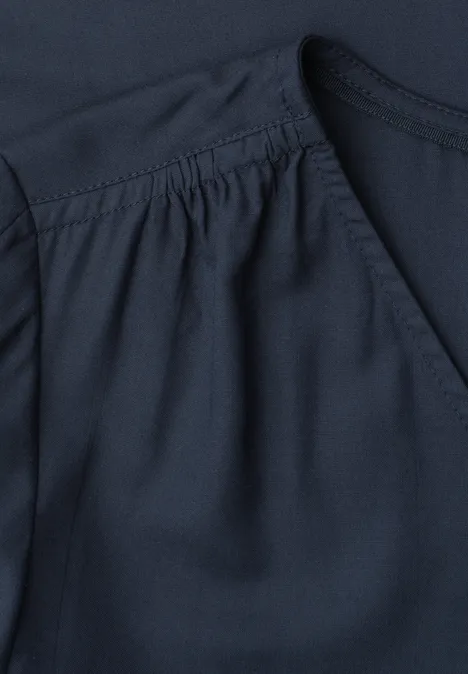 Blouseshirt met korte mouwen en V-hals shadowed navy Close-up van een donkerblauw kledingstuk met plooien bij de schouder.