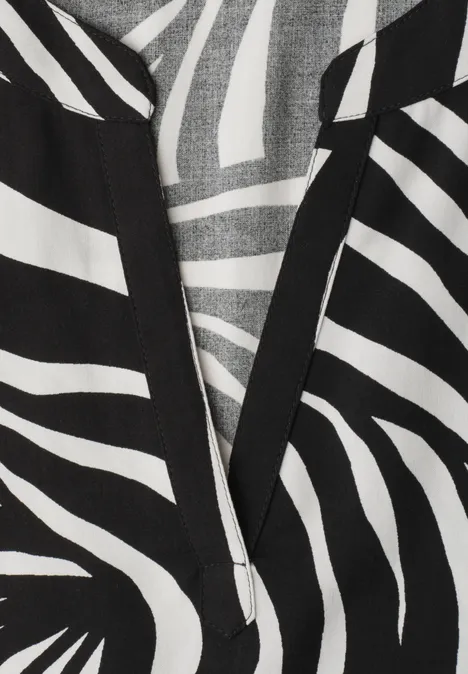 Zwart-wit zebraprint op stof met V-hals, grafische modeprint.