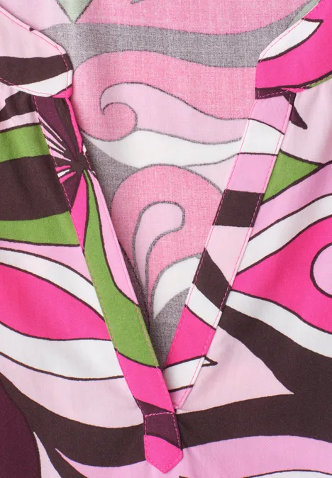 Stuk kleurrijke stof met golvende roze, groene, witte en bruine lijnen en vormen.