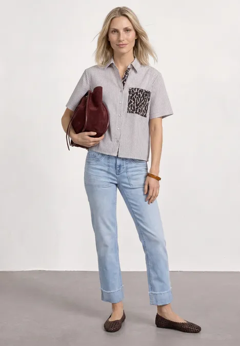 Kurzarm Hemdbluse mit Leo-Details light terra mocha Frau trägt kurzärmliges, helles Hemd mit gemusteter Tasche, helle Jeans, flache Mokassins und trägt eine Handtasche.