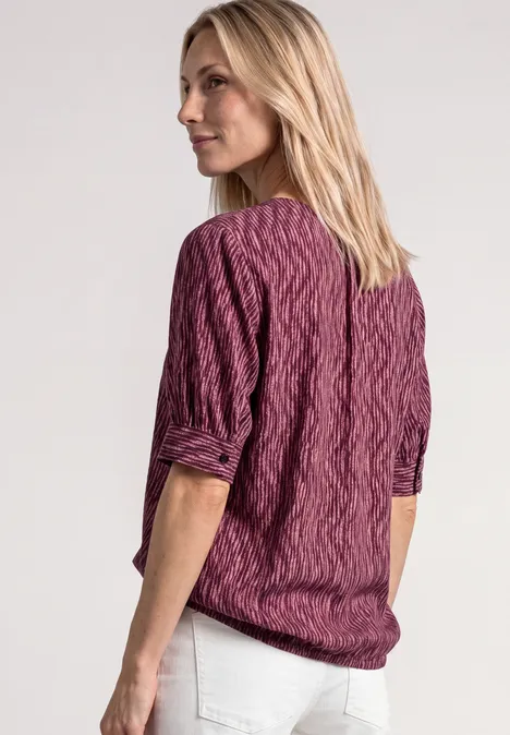 Blouse met korte mouwen, gespleten hals en elastische zoom blush berry Achteraanzicht van een vrouw met blond haar in een paarse kabeltrui en witte broek voor een lichte achtergrond.
