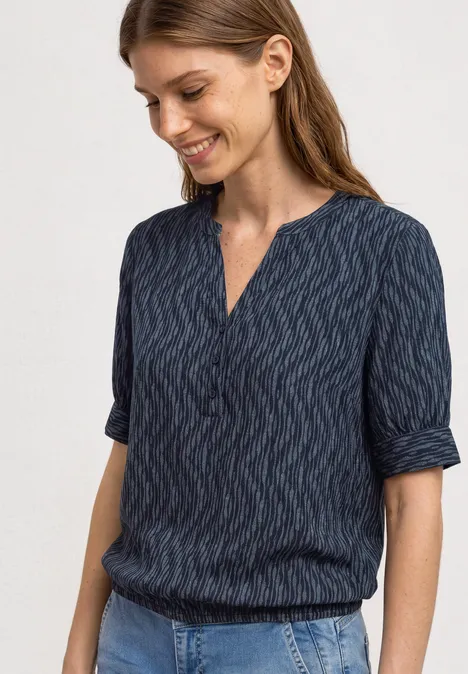 Blouse met korte mouwen, gespleten hals en elastische zoom ashen blue Een vrouw draagt een donkerblauwe blouse met subtiel patroon en driekwart mouwen.