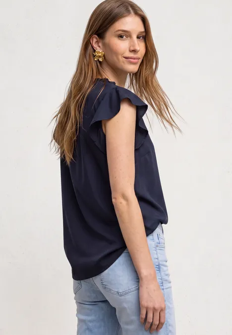 Blusenshirt mit Split Neck und Volant-Ärmeln darkest blue Eine lächelnde junge Frau in dunkelblauer Bluse mit Rüschenärmeln und Jeans seitlich fotografiert