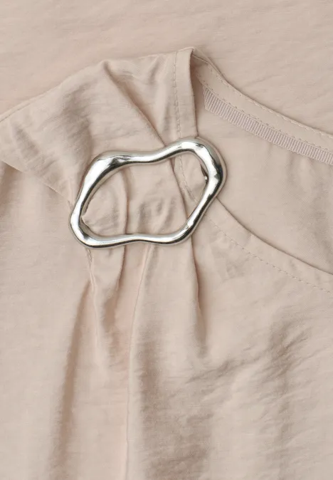 Blusenshirt mit Rundhals und Schnallendetail clay sand Nahaufnahme eines beigen Oberteils aus zartem Stoff mit unregelmäßigem silbernem Ring an der Schulterpartie.