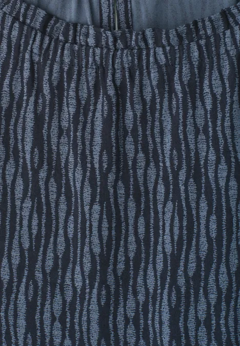 Tissu bleu foncé à taille élastique orné de motifs de feuilles gris ondulées.