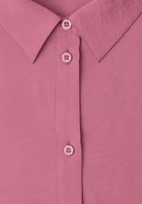 Gros plan sur une chemise rose avec patte de boutonnage et col