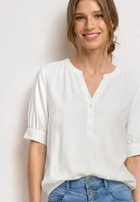 Blouse met korte mouwen, split in de hals en elastische zoom off white Frau trägt weiße Bluse mit halblangen Ärmeln und Knopfleiste, locker in Jeans gesteckt.
