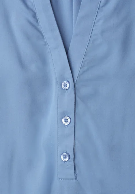 Blouse met korte mouwen, split in de hals en elastische zoom northern blue Nahaufnahme eines hellblauen Hemds mit Knopfleiste und drei Knöpfen.