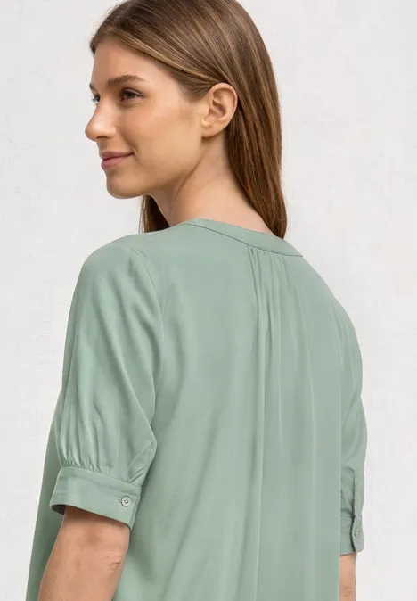 Kurzarm Bluse mit Split Neck und Elastiksaum eucalyptus green Frau von hinten in salbeigrüner Bluse mit halblangen Ärmeln.