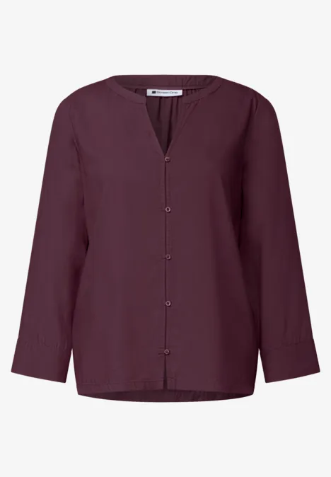 Chemisier femme bordeaux à col V, manches longues et boutonné sur le devant.