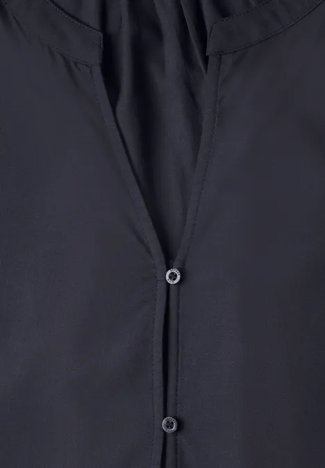 Schwarze Bluse mit V-Ausschnitt und zwei Knöpfen.