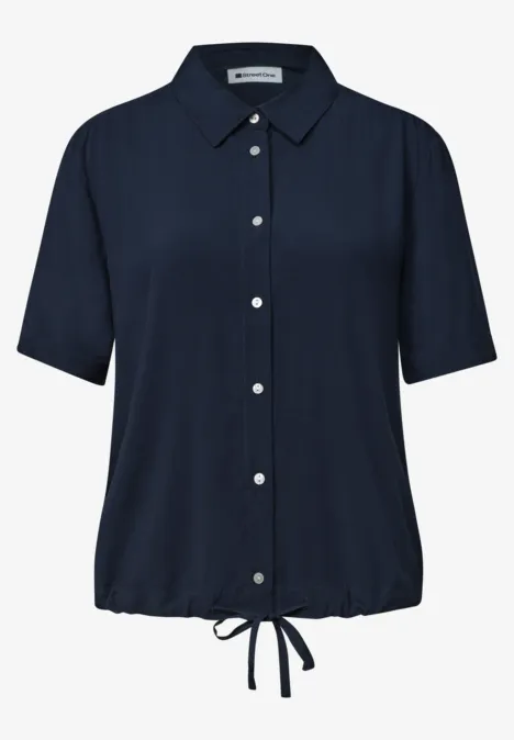 Chemise à manches courtes bleu foncé avec boutons et cordon ajustable.