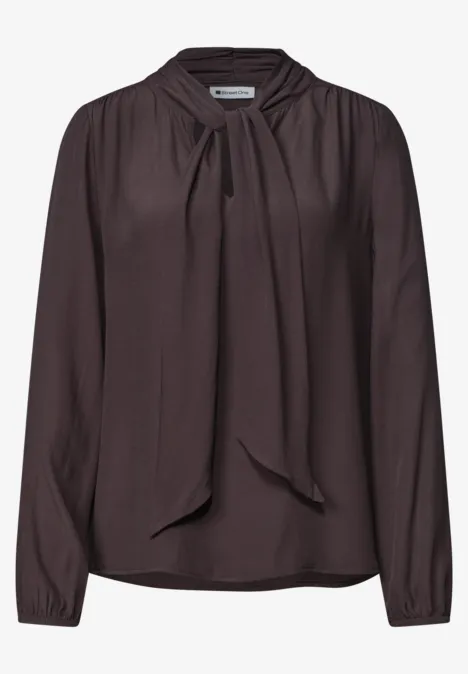 Dunkelbraune, langärmelige Bluse mit locker sitzendem Schleifenkragen.