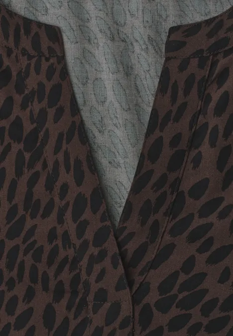 Nahaufnahme eines Kleidungsstücks mit braunem Leopardenmuster und grauer Innenseite.