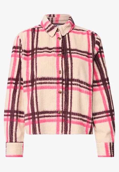 Flauschige Hemdjacke mit beigem Grund und pink-braunem Karo-Muster, Knopfleiste und Brusttasche.
